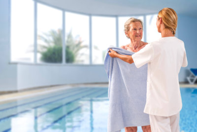 woman giving senior woman a towel