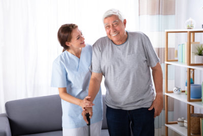 woman helping senior man walk around